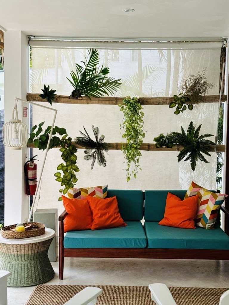 Salón moderno y sofá turquesa con plantas exóticas en Villa Vitao Garden